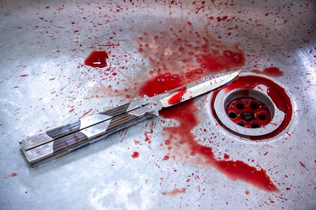 Conceptual image of a sharp knife with blood in sink background.kill conceptの写真素材