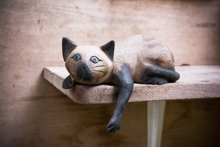 Wooden cat doll on wooden shelfの写真素材