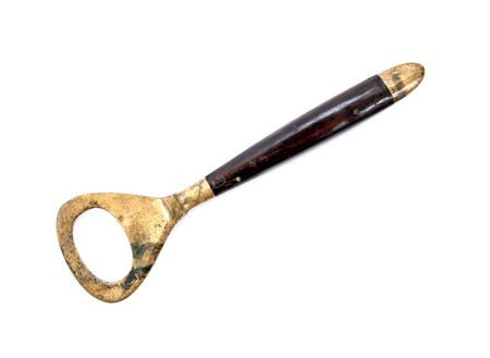 Old vintage retro bottle opener isolated on white background.Brass bottle opener isolatedの写真素材
