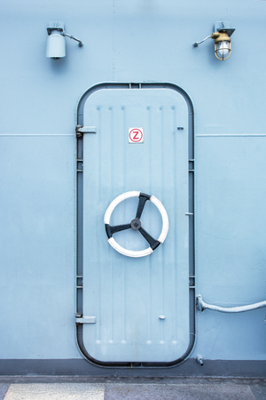 Battleship iron door with steering wheel lock and light bulb backgroundの写真素材