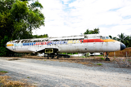 Closeup of abandoned airplane beside the road with tree and sky backgroundの写真素材