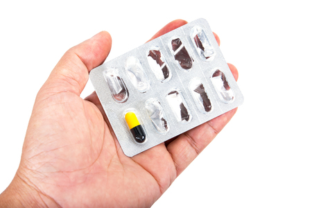 Last capsule medicine with drug panel in hand isolated on white background. Capsule medicine with packaged in palm isolatedの写真素材