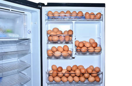 Many eggs in refrigerator isolated on white background. A lot of chicken eggs in refrigerator door isolatedの写真素材