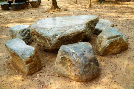 Rock table and chair in the garden background. Large nature stone table and chairs in the parkの写真素材