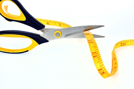 scissors cutting a measuring tapeの写真素材