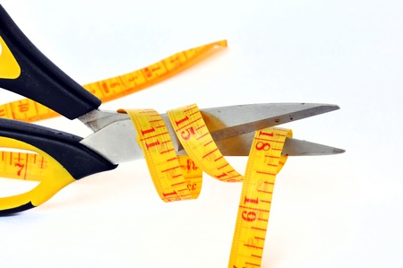 scissors cutting a measuring tapeの写真素材