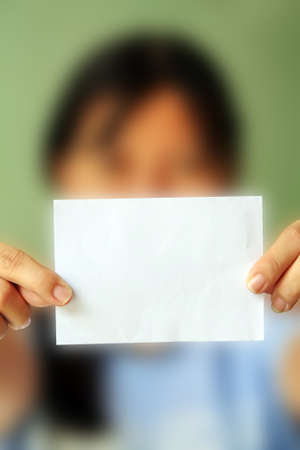 woman holding a blank business card in front of her の写真素材