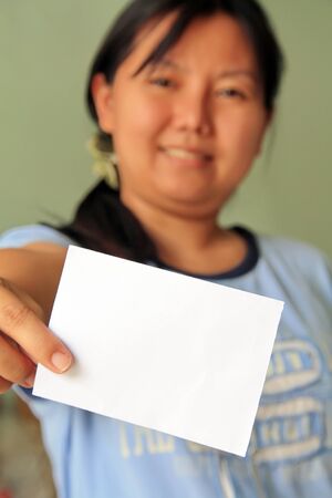 woman holding a blank business card in front of her の写真素材