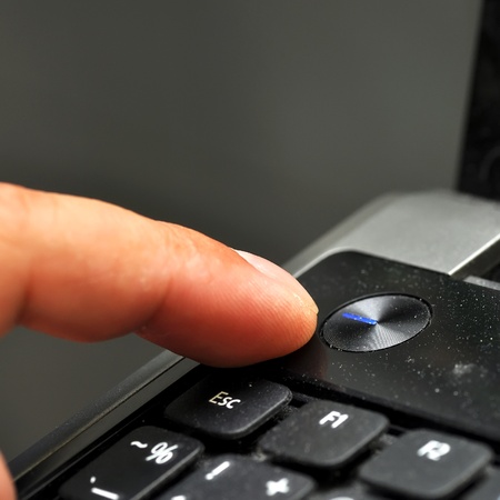Finger pressing power button on laptop keyboard