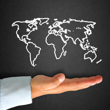World map in blackboard with handの写真素材
