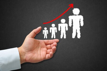Human hand with human icon and business graph on a blackboardの写真素材