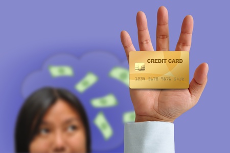 Hand holding credit card with Woman thought Bubbles of Moneyの写真素材