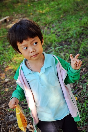 Young asian boy pretend to show two fingersの写真素材