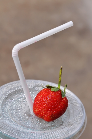 White drinking straw and strawberry on the disposable plastic cupの写真素材