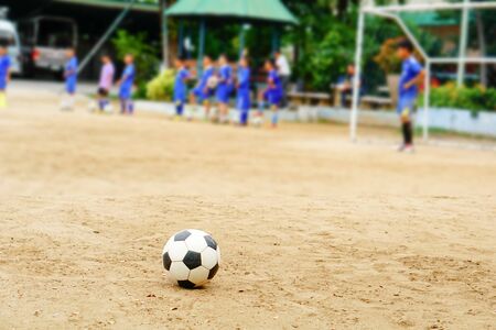 The kids enjoyed playing soccer on the dusty field after school.の写真素材