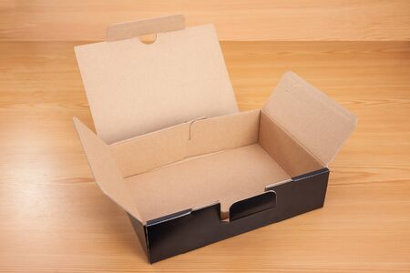 Open blank black box mock up on wood background.