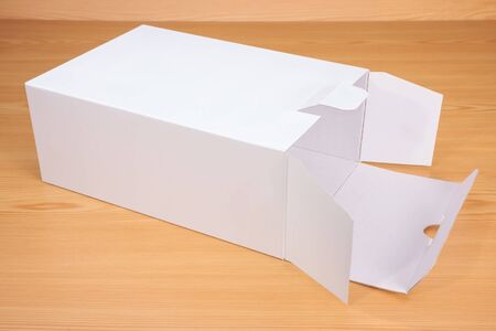 Open blank white box mock up on wood background.