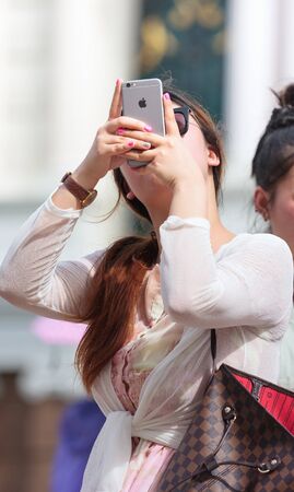 Bangkok, Thailand - June 13, 2015: Female tourist takes a photograph with smart phone at Grand Palace Bangkok, Nowadays Photography with camera on smart phone become popular because ability snap and share to social network in one drviceのeditorial素材