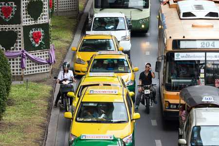 Bangkok, Thailand - August 1, 2015: Two motorcyclists stop at the red light in between a gap of...