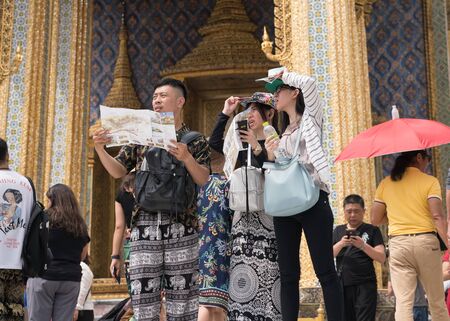 Bangkok, Thailand - October 15, 2018: Chinese tourists visit Wat Phra Kaew by using a tourist brochure, Grand Palace, Bangkokのeditorial素材