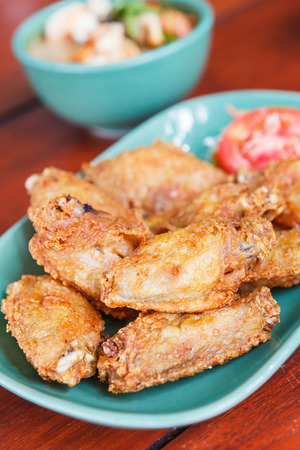 Fried chicken wings on a wooden table. thai food.の写真素材