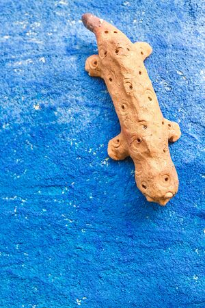 Doll lizard clay on blue wall.の写真素材