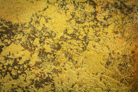 Abstract background texture of stone wall in yellow gold tone. Grunge wall. Cement wall texture and background with copy space for text or image. Dark edgedの写真素材