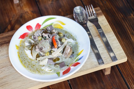 Green curry chicken with Thai rice noodles on wooden table. Thai Food.の写真素材