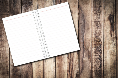 Open notebook paper with line on  wood background for design with copy space for text or image.の写真素材