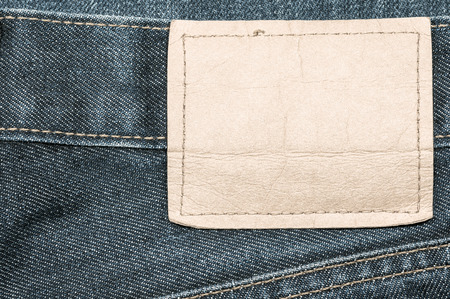 Denim jeans fabric texture background with blank leather label for beauty, fashion and clothing idea...