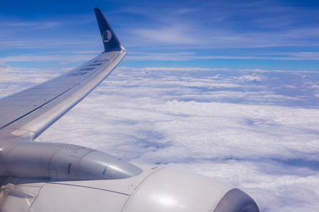 Chiang Mai, THAILAND - May 7, 2019 : Airplane wing and beautiful sky with cloud view from Shandong Airlines airplane window seat.のeditorial素材