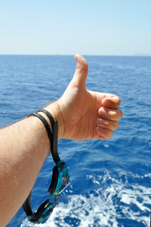 hand with goggles for diving on the sea backgroundの写真素材