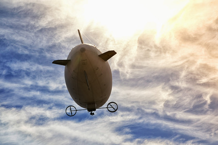 airship flying in the blue cloudy skyの写真素材