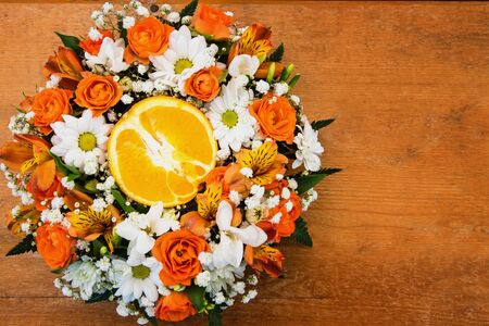 Bouquet of roses and daisies with orange in the centerの写真素材