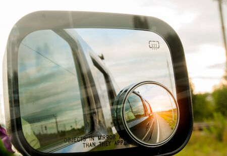 sunset reflected in the mirror of a carの写真素材