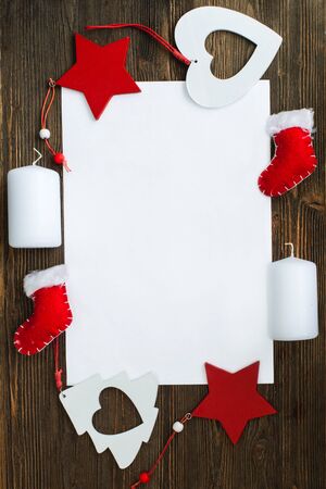 A sheet of paper and a variety of Christmas ornaments on the wooden backgroundの写真素材