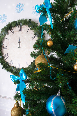 Decorations on the Christmas tree and clock on the background with small depth of focusの写真素材