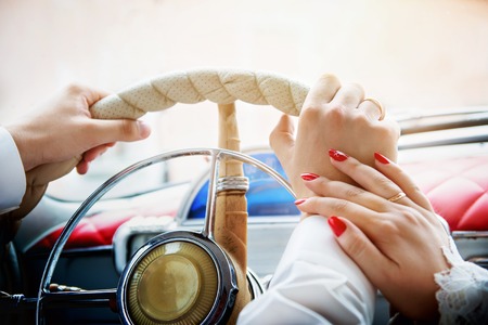 hands of man and woman on a car steering wheelの写真素材