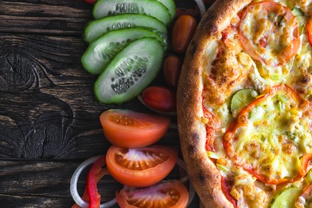 pizza and components lie side by side on the boardの写真素材