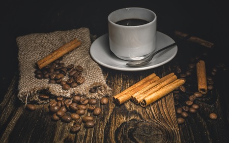 cinnamon cup of coffee and grain on a wooden backgroundの写真素材