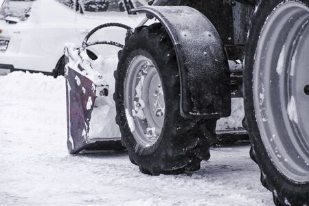 Tractor rides and cleans the road from the snowの写真素材