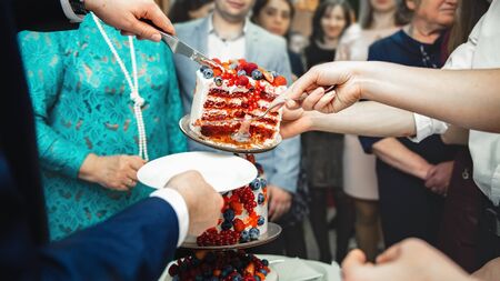 Handing out cake to people at shallow depth of fieldの写真素材