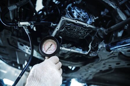 hand in a white glove holds a pressure gauge at shallow depth of fieldの写真素材