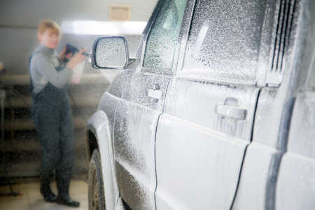 Applying a foam solution to a car at a shallow depth of field. One of the stages of car washの写真素材