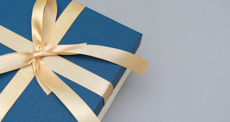 close-up blue gift box gold ribbon on grey background. concept for luxury giftの写真素材