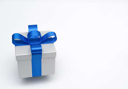 silver gift box with blue satin bow ribbon on white background.concept for happy surprise father's...