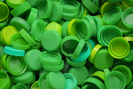 top view green color collection of LDPE plastic bottle cap remove lid waste for recycle process background.idea for environment issue,recycling backdrop.の写真素材