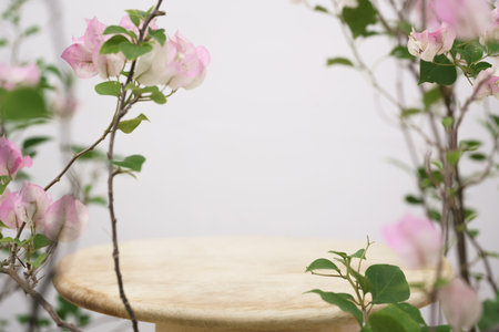 empty wooden podium blurred pink  flowers decoration on white background with space.beauty cosmetic...