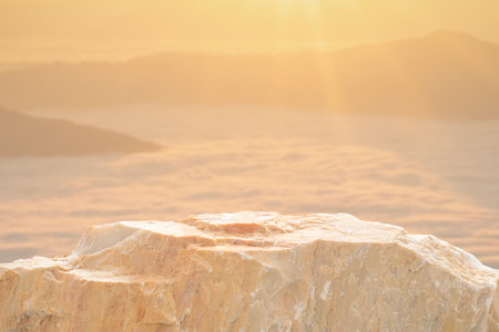 Stone podium table top with outdoor mountains golden color scene nature landscape at sunrise blur background.Natural beauty cosmetic or healthy product placement presentation pedestal display.の写真素材