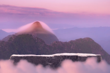 Stone podium outdoors on sky pink pastel soft cloud with misty mountain nature landscape background.Beauty cosmetic product placement pedestal present minimal display,summer paradise dreamy concept.の写真素材